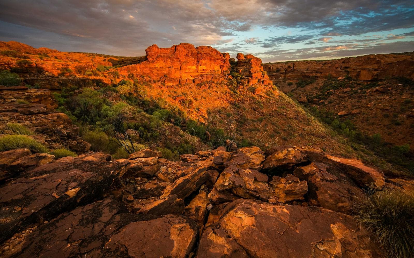 Campo aberto com montanhas ao fundo sob céu nublado